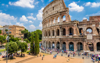 Colosseum with clear blue sky and clouds in Rome, Italy