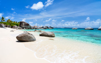 Beautiful tropical beach with white sand, turquoise ocean water and blue sky at Virgin Gorda, British Virgin Islands in Caribbean (Photo via shalamov / iStock / Getty Images Plus)