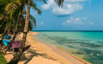 tropical beach with hammock on palm, relax concept from Nicaragua (Photo via riderfoot / iStock / Getty Images Plus)