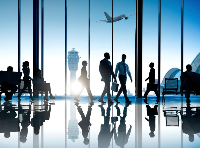 Corporate or business travelers walking through the airport. 