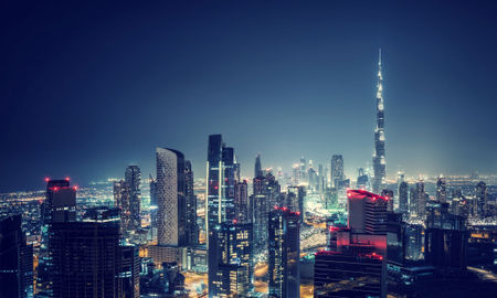 Beautiful Dubai cityscape, bird&#39;s eye view on a night urban scene, modern city panoramic landscape, United Arab Emirates (photo via Anna_Om / iStock / Getty Images Plus)