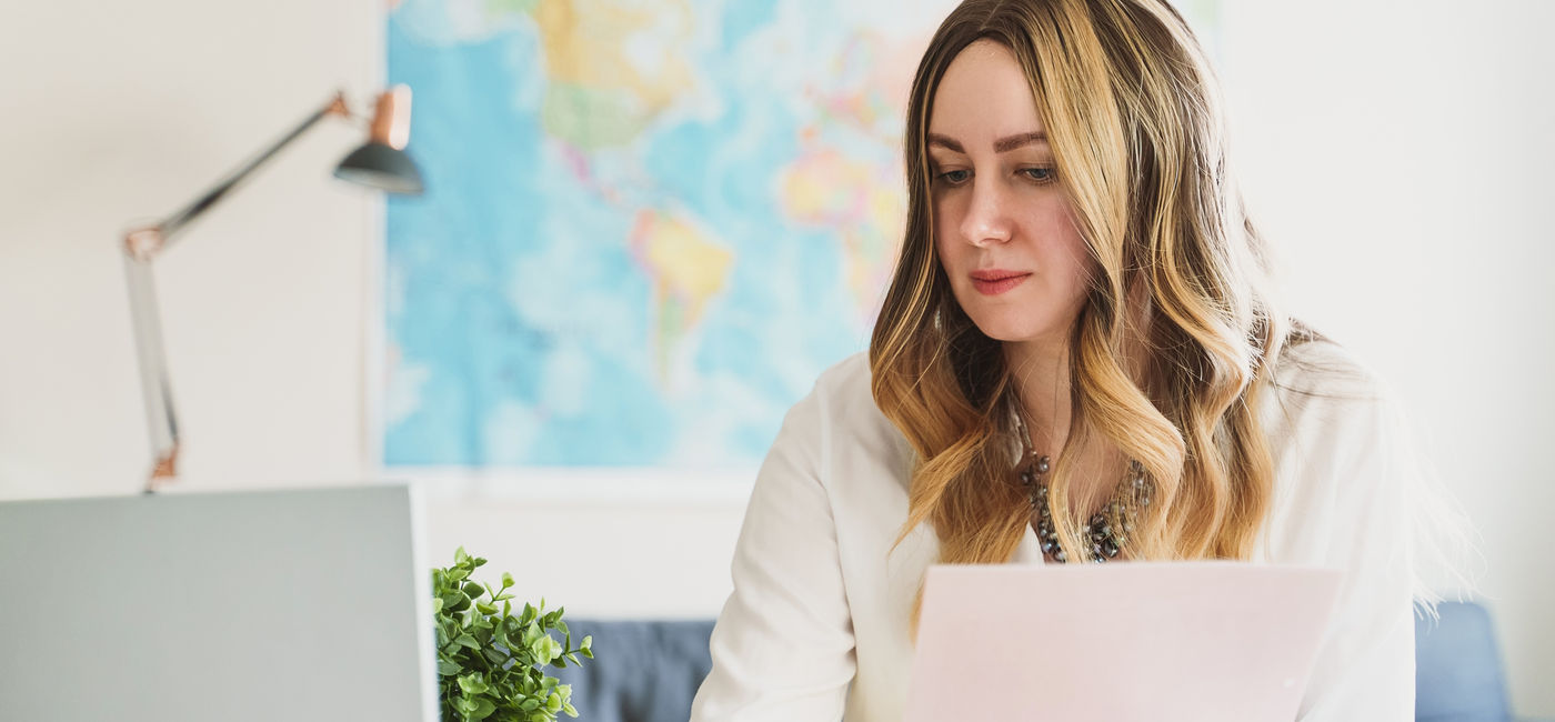 Image: A travel advisor working on her computer. (Photo Credit: Adobe Stock/M-Production)