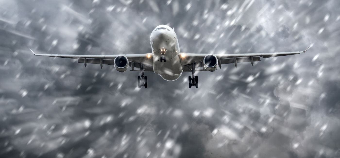 Image: Airplane flying in a snowstorm. (Photo Credit: Adobe Stock/aapsky)