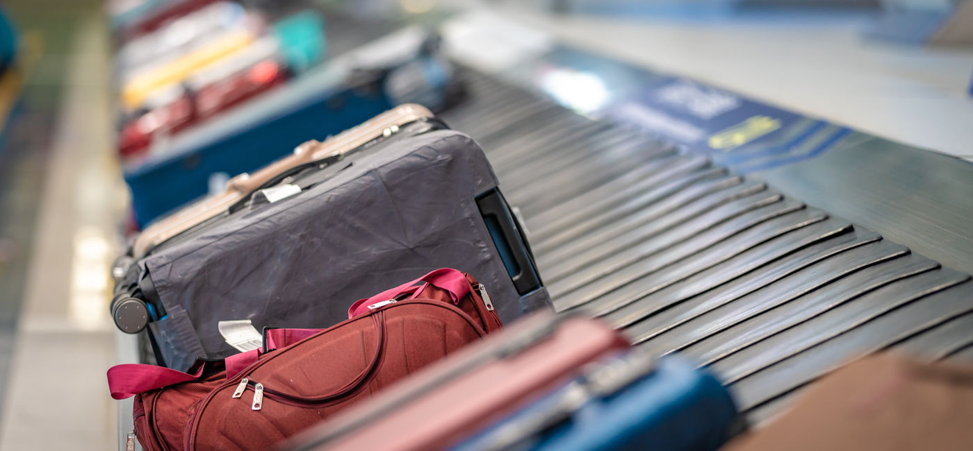 Image: Checked luggage at baggage claim. (Photo Credit: Aris Suwanmalee/Adobe Stock)