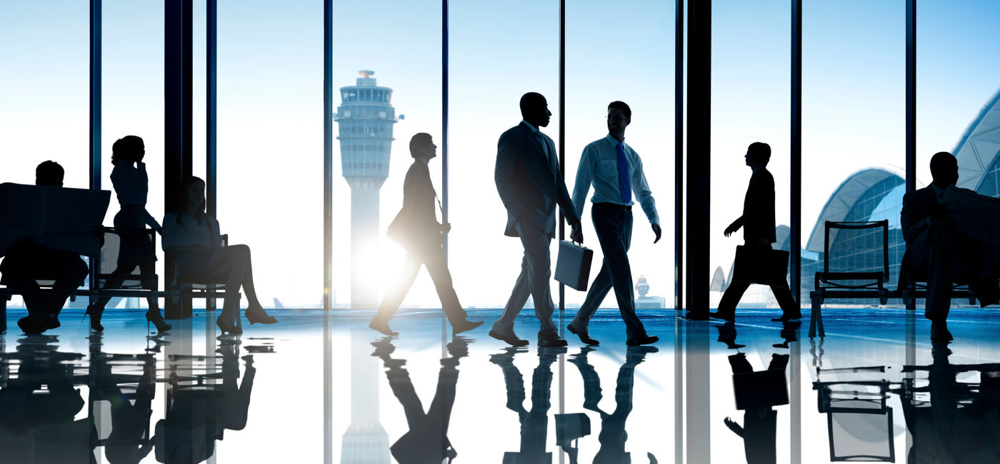 Image: Corporate or business travelers walking through the airport. (Photo Credit: Adobe Stock/Rawpixel.com)