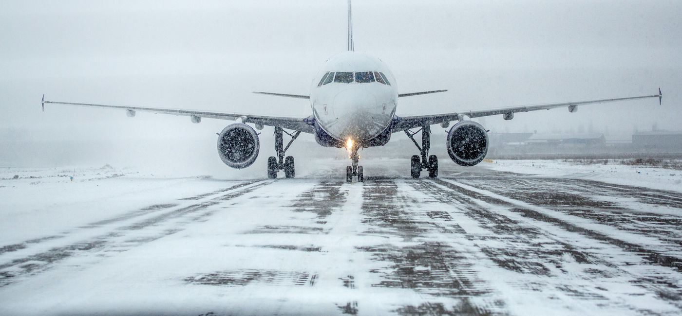 Image: Passenger plane in snow at airport (Photo Credit: Alexey Lesik, Adobe Stock)