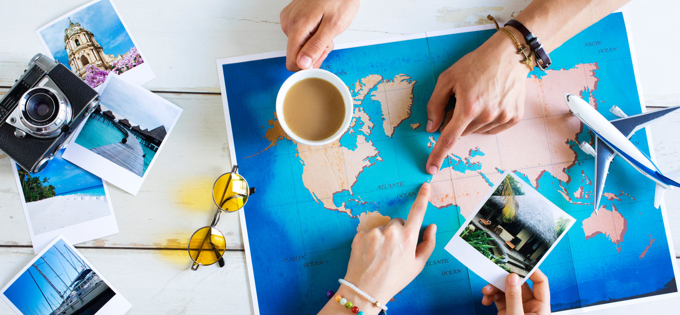 Image: Travel advisor helping plan a trip. (Photo Credit: sebra/Adobe Stock)