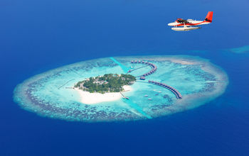 Sea plane flying above Maldives islands, Raa atol (photo via Jag_cz / iStock / Getty Images Plus)