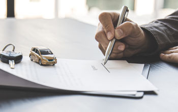 Traveler signing a rental car agreement