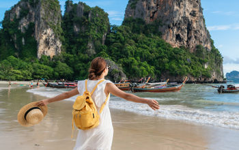 Young female traveler enjoying a summer vacation on a tropical beach in Krabi, Thailand.