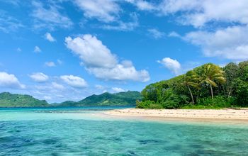 Island with turquoise water, white sand beach, blue sky