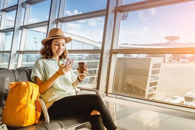 Traveler using her phone at the airport