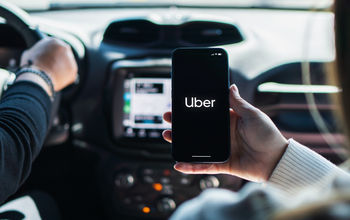 Car passenger using the Uber app on her mobile phone.